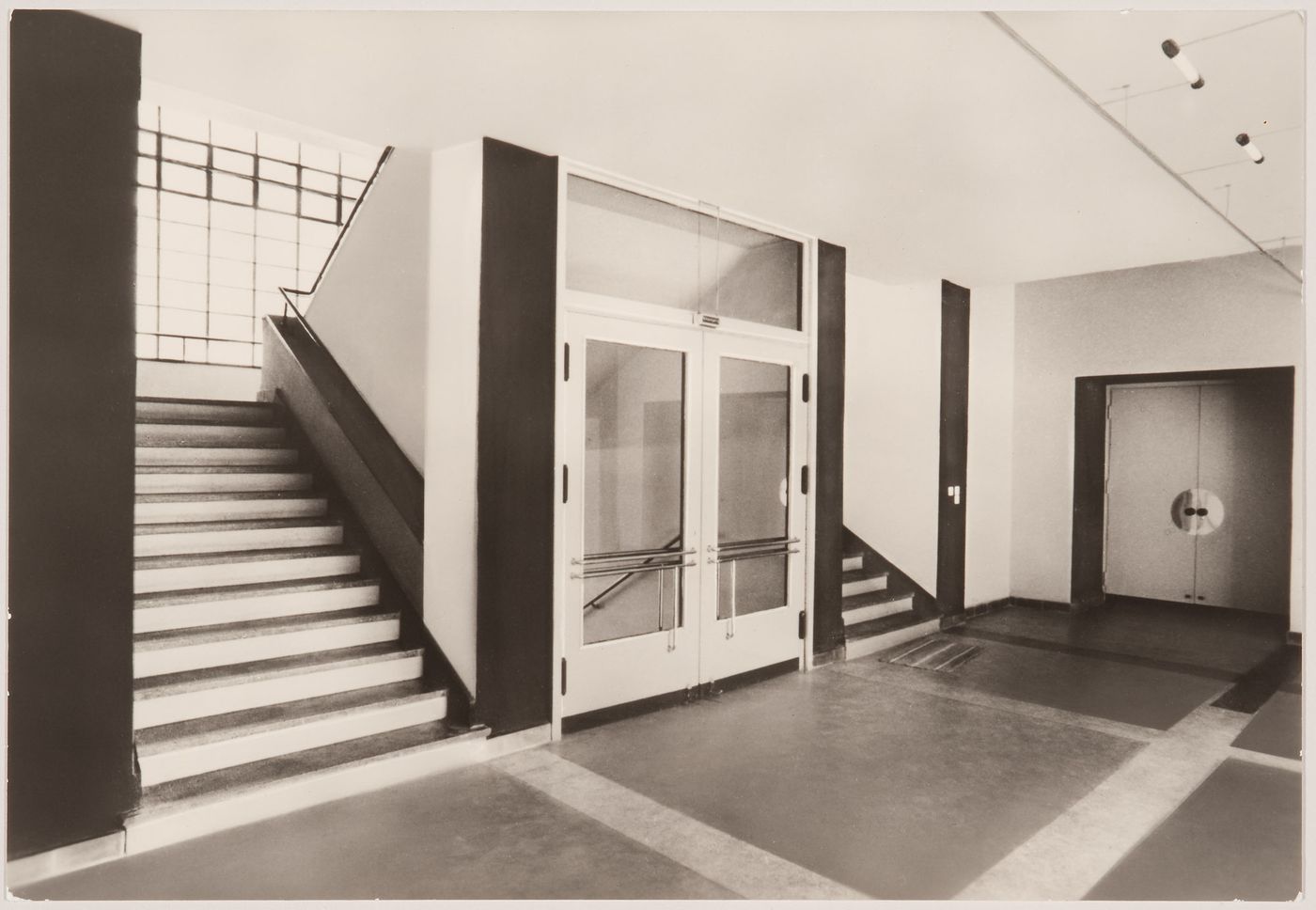Interior view of the workshop wing of the Bauhaus building showing the vestibule doors and stairs, Dessau, Germany