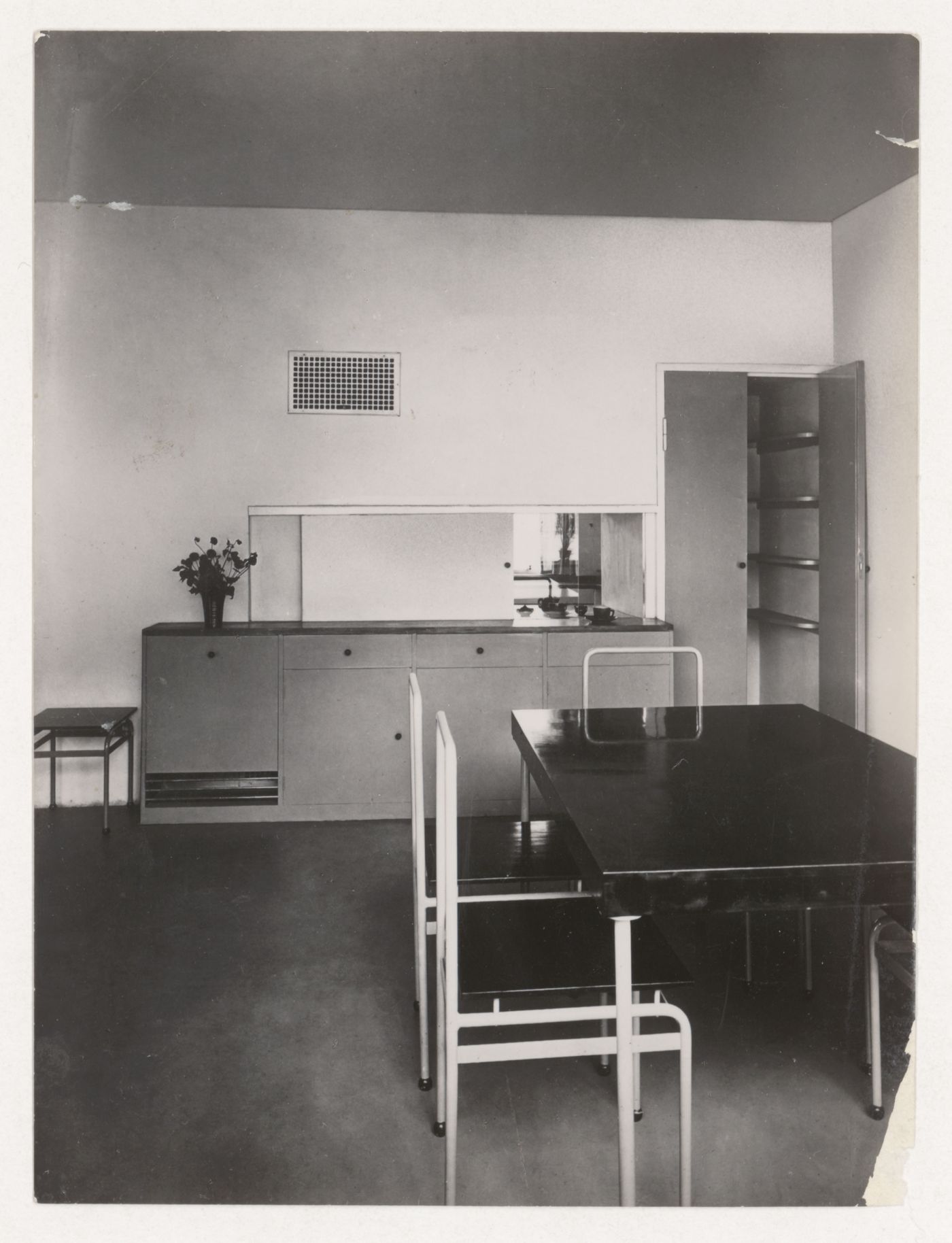 Interior view of the dining room of House 8 showing a table, chairs, buffet and serving window open to the kitchen, Weissenhofsiedlung, Stuttgart, Germany