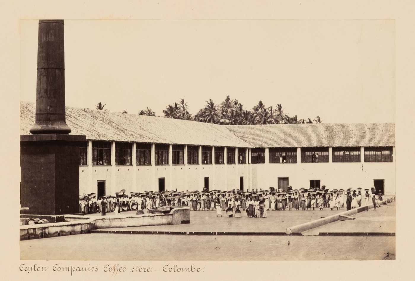 View of a coffee store with a column on the left and people in the courtyard, Colombo, Ceylon (now Sri Lanka)