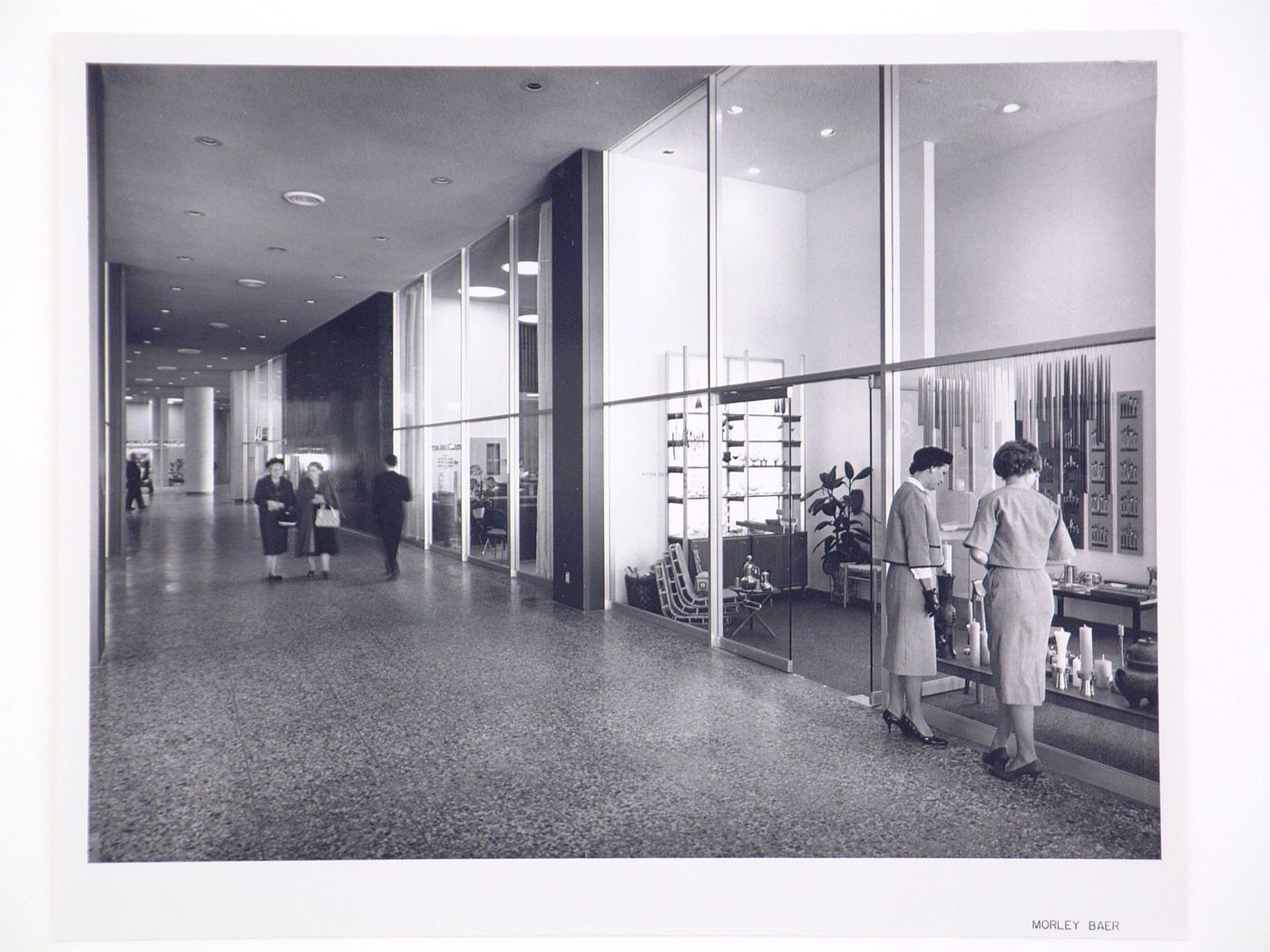 Interior view of the Kaiser Center office building showing a corridor, a store, an office and people, Oakland, California