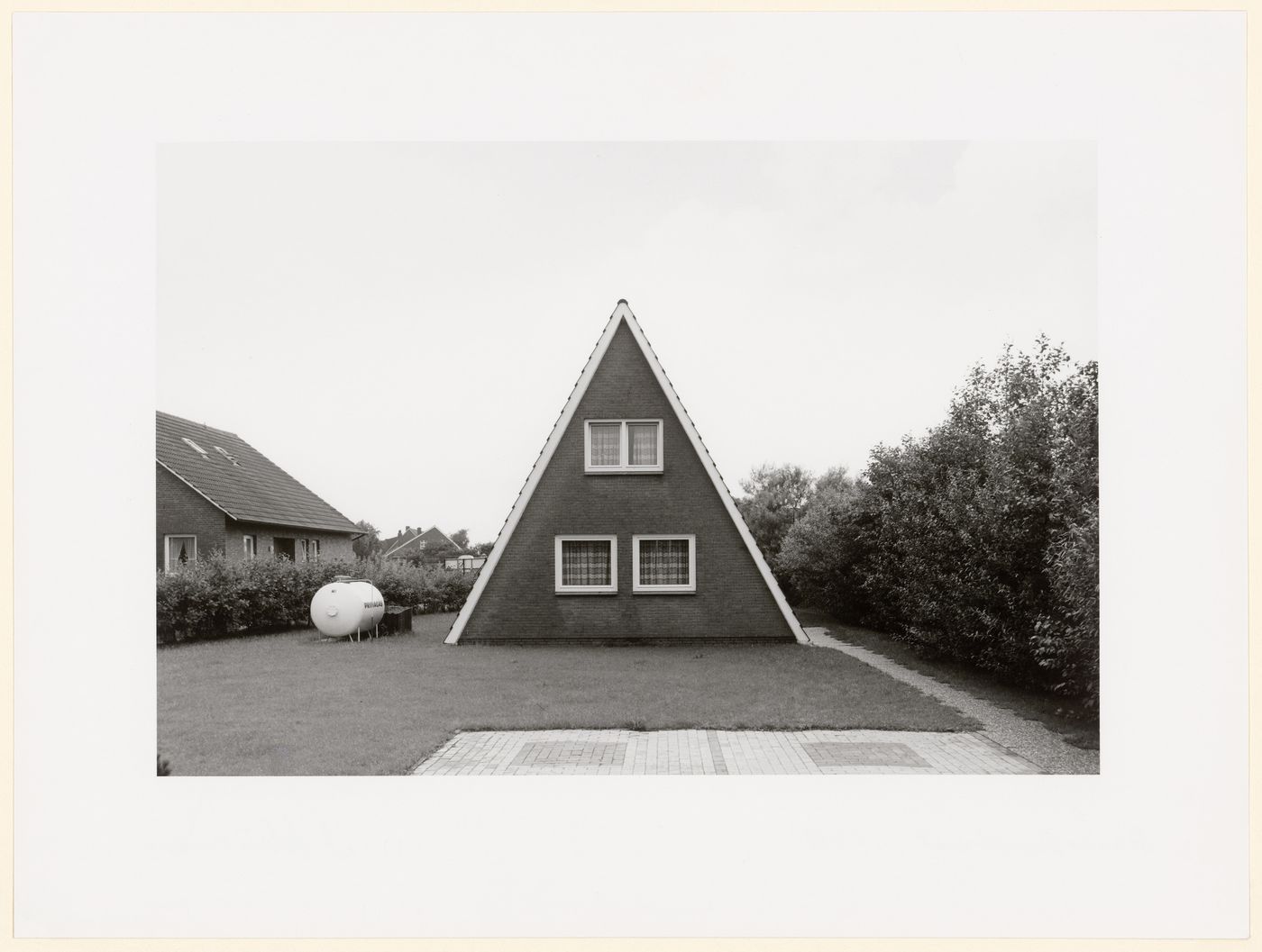 Brick A-frame house, with gas-storage tank in yard,  Dornumersiel, Germany