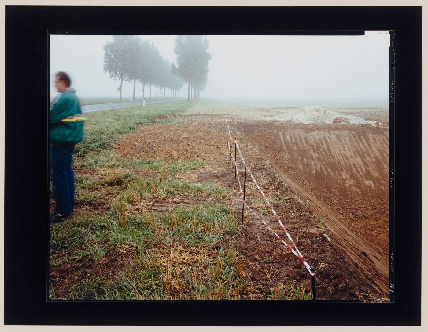 View of an excavation showing a man and a tree-lined road, Leuze, near Namur, Belgium (from the series "In between cities")