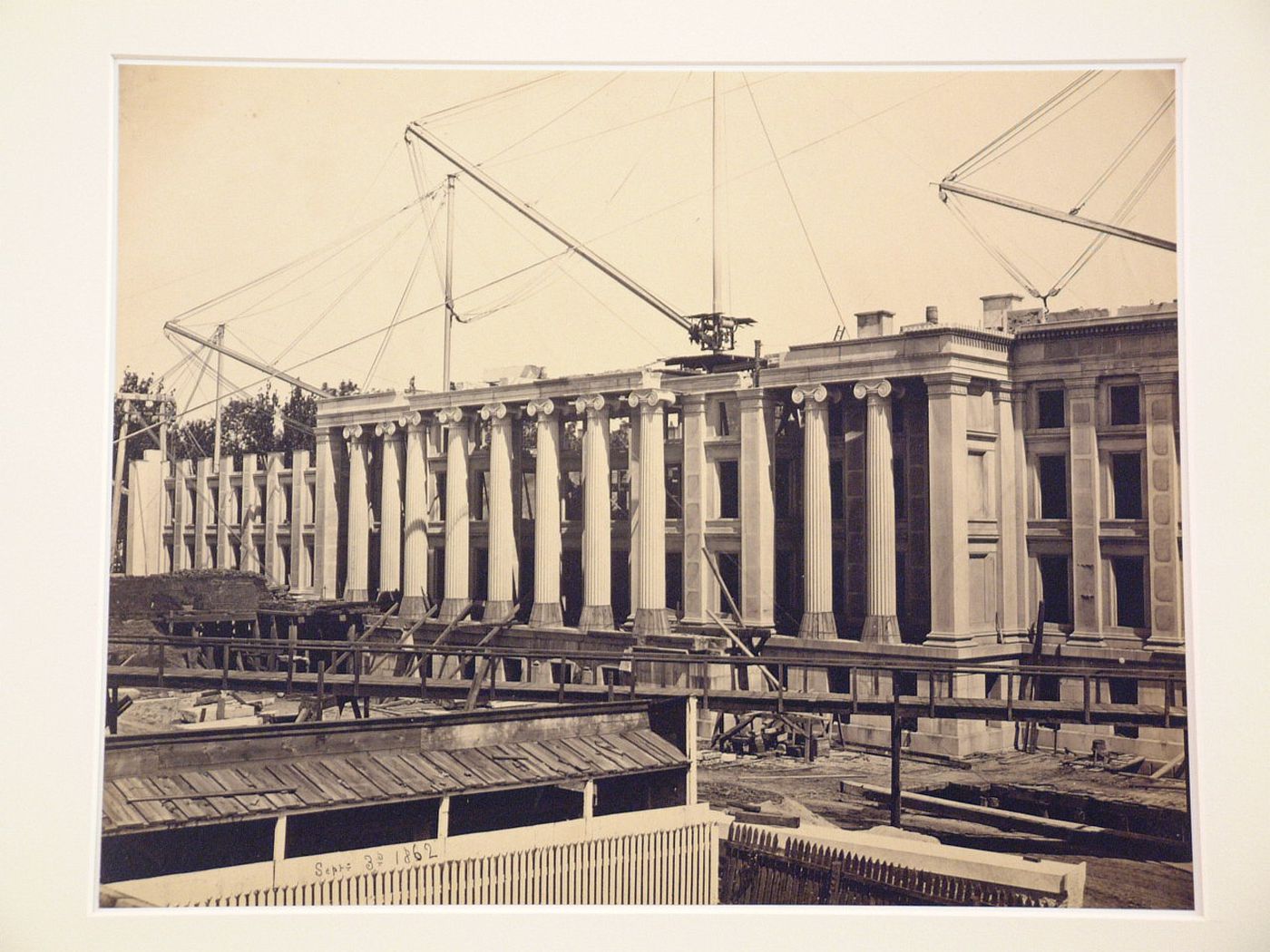 Treasury Building under contruction: View of work building and ramps in front, three cranes on roof, Washington, District of Columbia