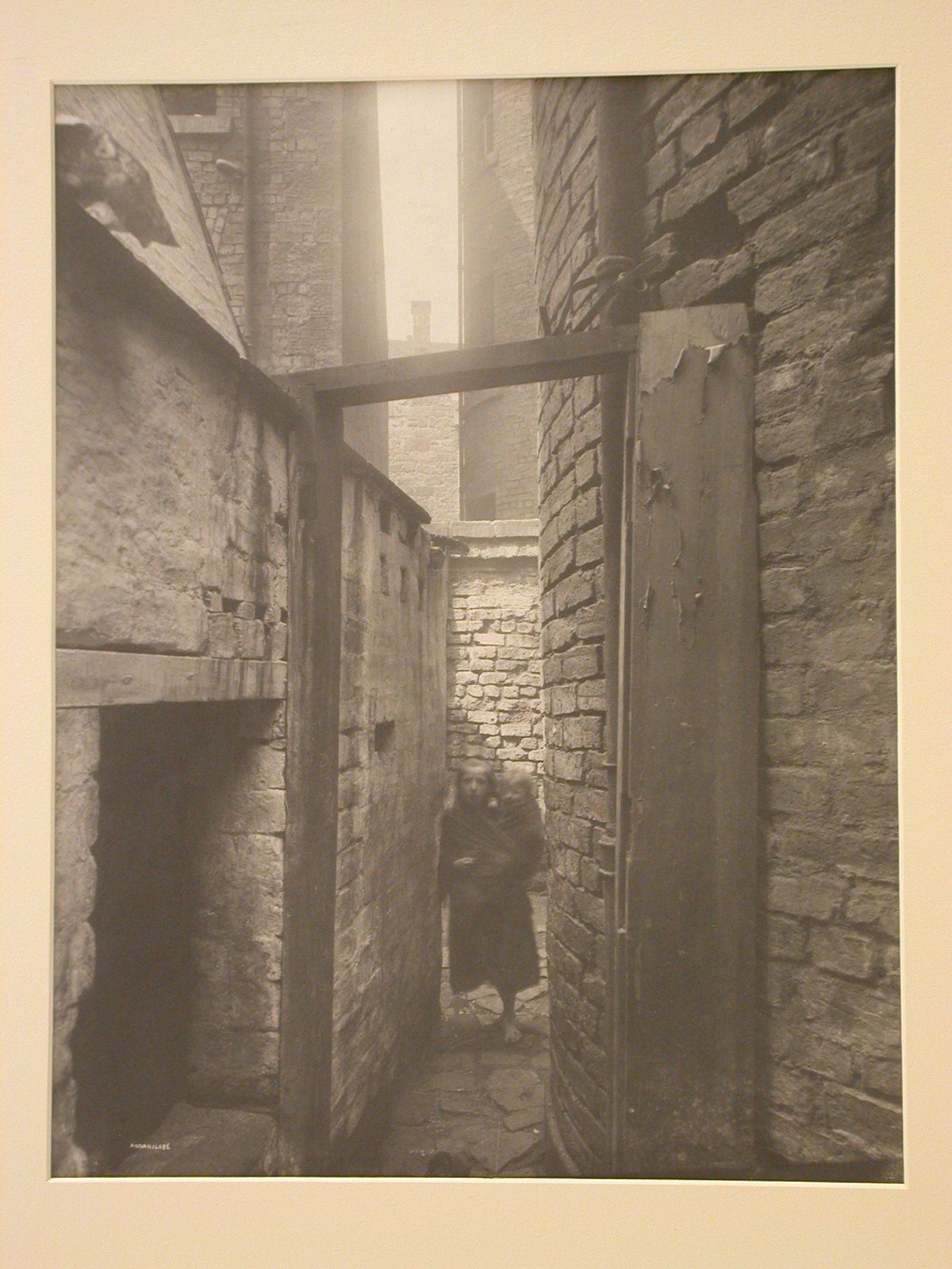View of a narrow passage with a little girl holding a baby, Glasgow, Scotland