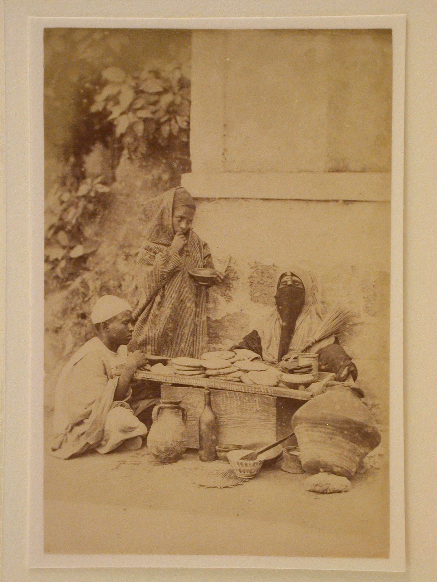 Three Egyptian figures seated around table