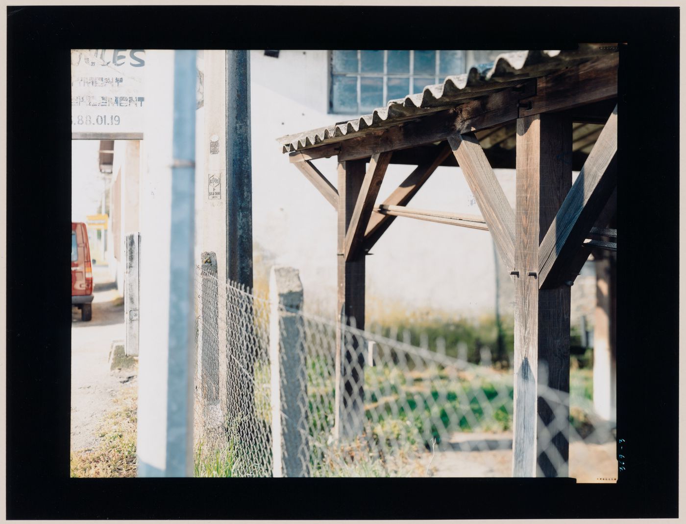 View of a canopy and a fence showing a building in the background, Sabres, France (from the series "In between cities")