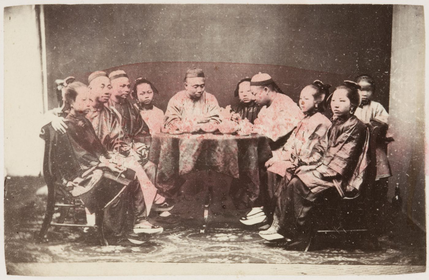 Portrait of a Chinese family seated around a table