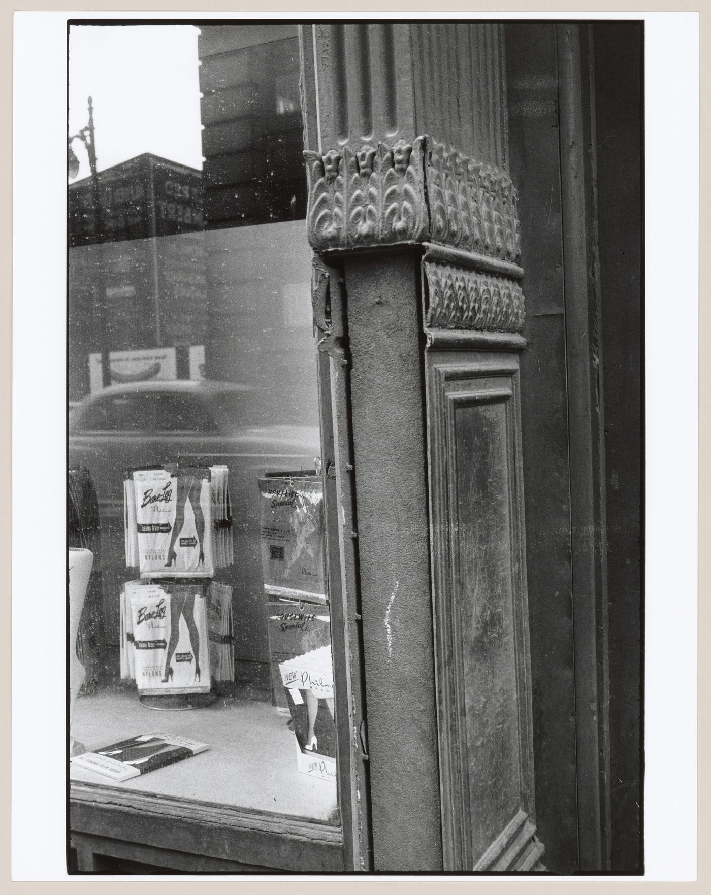 View of a show-window and a cast iron column with one panel missing showing the inner shaft, rue Notre-Dame, Montréal, Québec, Canada