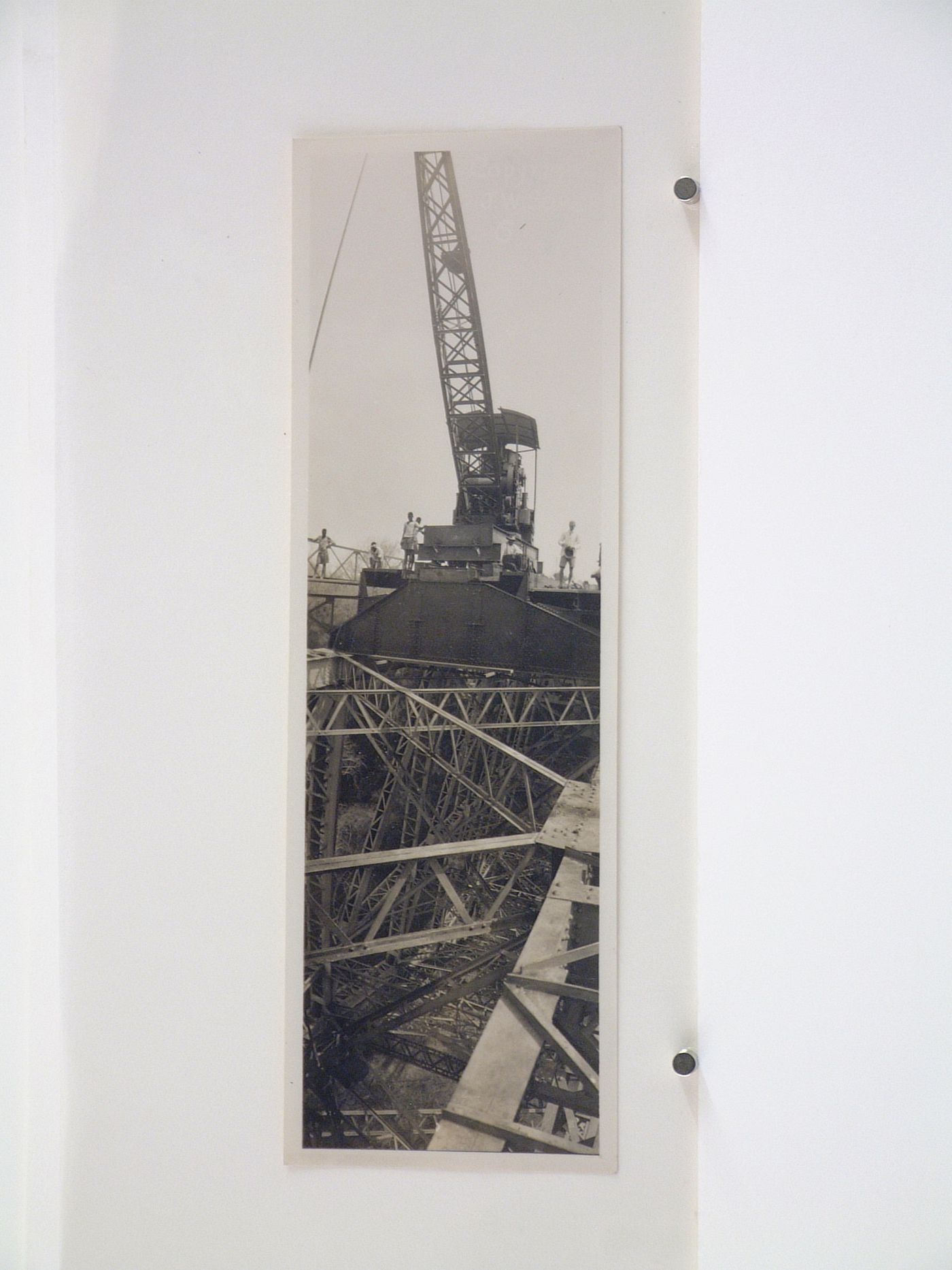 Vertical panoramic view of steel beams and people standing by a crane during construction of the railway on Victoria Falls Bridge, Zambezi River, crossing the border between Victoria Falls, Zimbabwe and Livingstone, Zambia