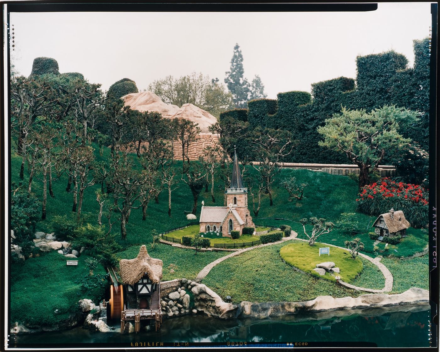 View of Storybook Land with miniature church, house and old mill on artificial stretch of water, Disneyland, Anaheim, California