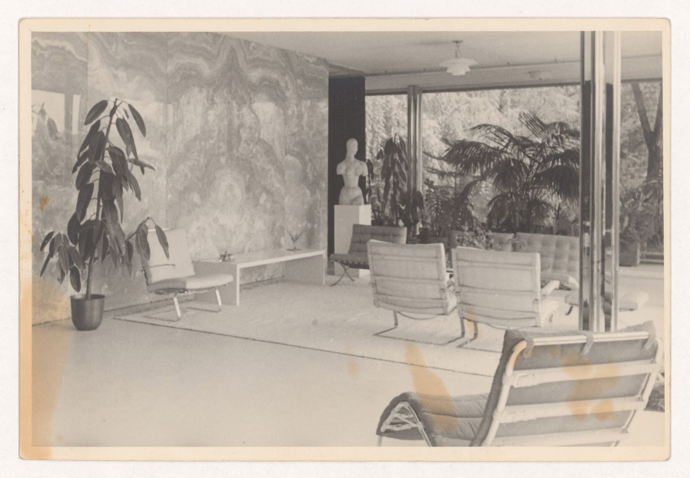 Interior view of the living area looking east showing the onyx wall and a statue on the left and a seating area in the centre, Tugendhat House, Brno, Czechoslovakia (now Czech Republic)