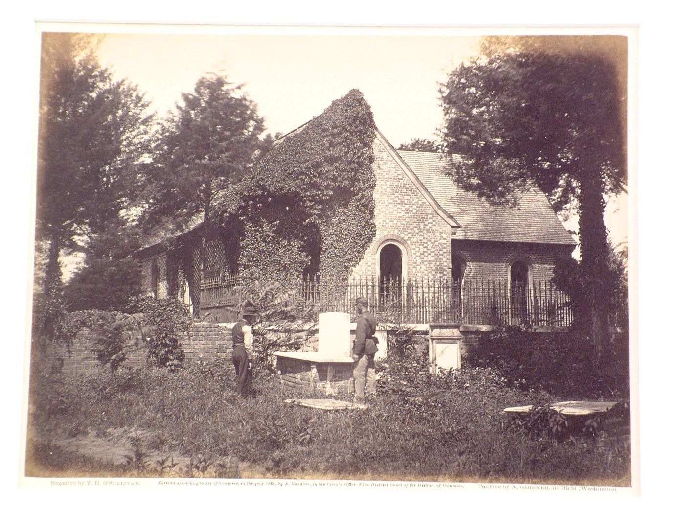 Rear view of Blandford Church (now Old Blandford Church of Bristol Parish) with a soldier and a man in the cemetery, Petersburg, Virginia, United States