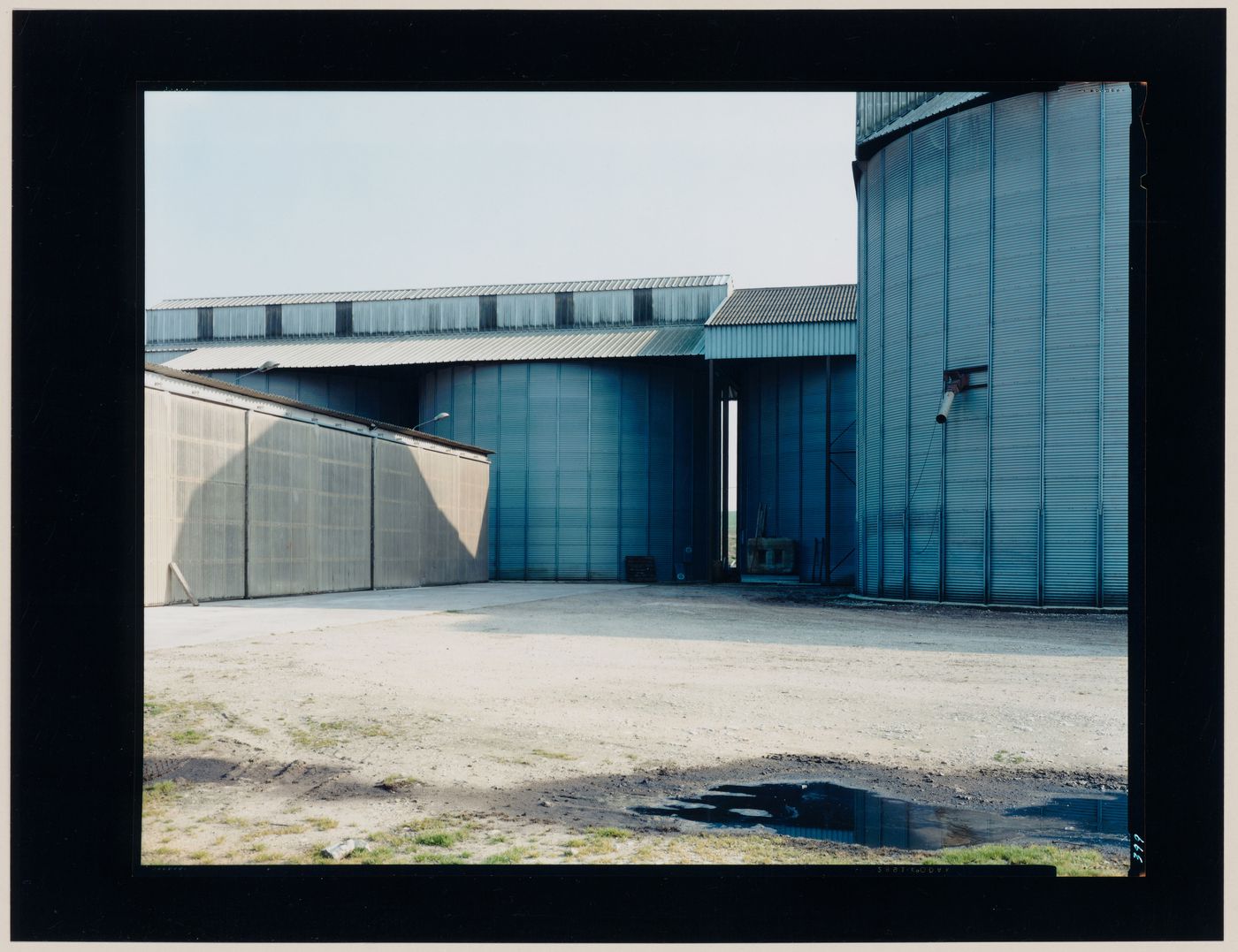 View of agricultural buildings and a yard, Lusignan, France (from the series "In between cities")