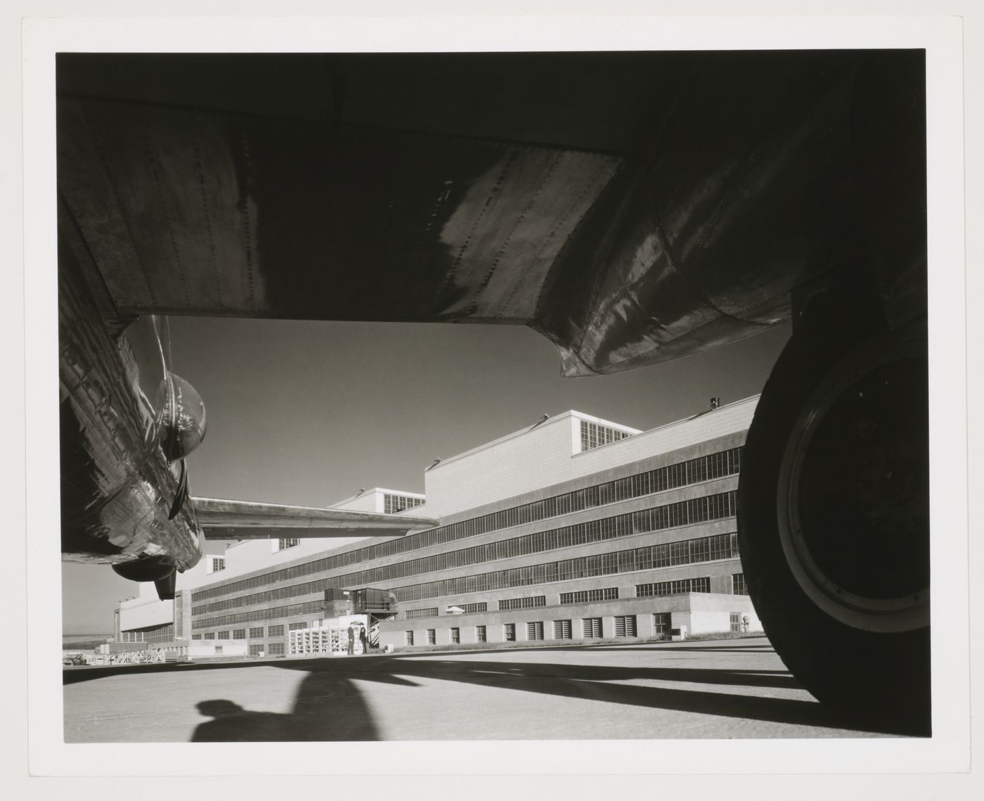 View of the rear [?] façade of the Manufacturing Building from beneath an airplane wing, Glenn L. Martin Company Bomber Plant, Omaha, Nebraska