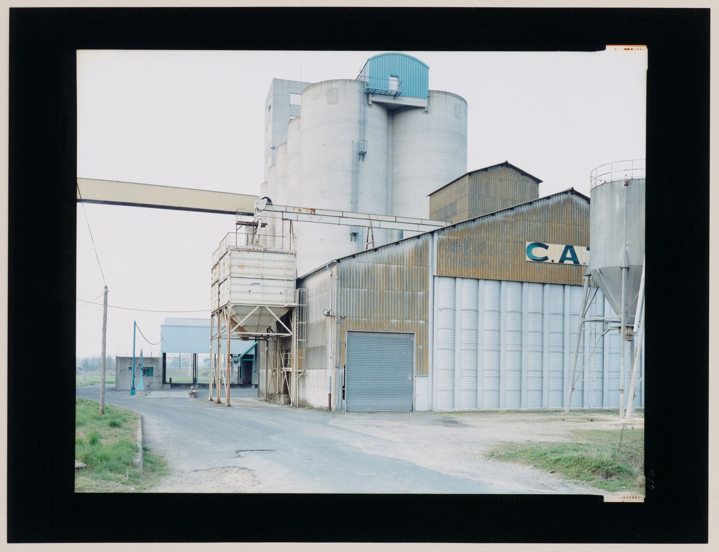 View of an agricultural building complex showing a silo and hoppers, Saint-Jean-d'Angély, France