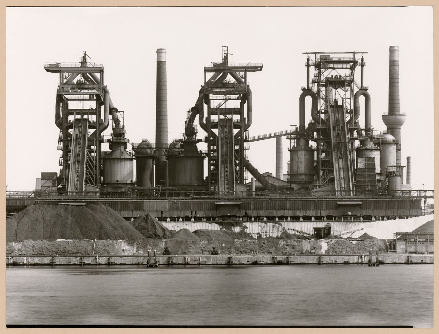 View of Metallhüttenwerk industrial plant showing blast furnace heads A, B, and C, Lübeck-Herrenwyk, Germany