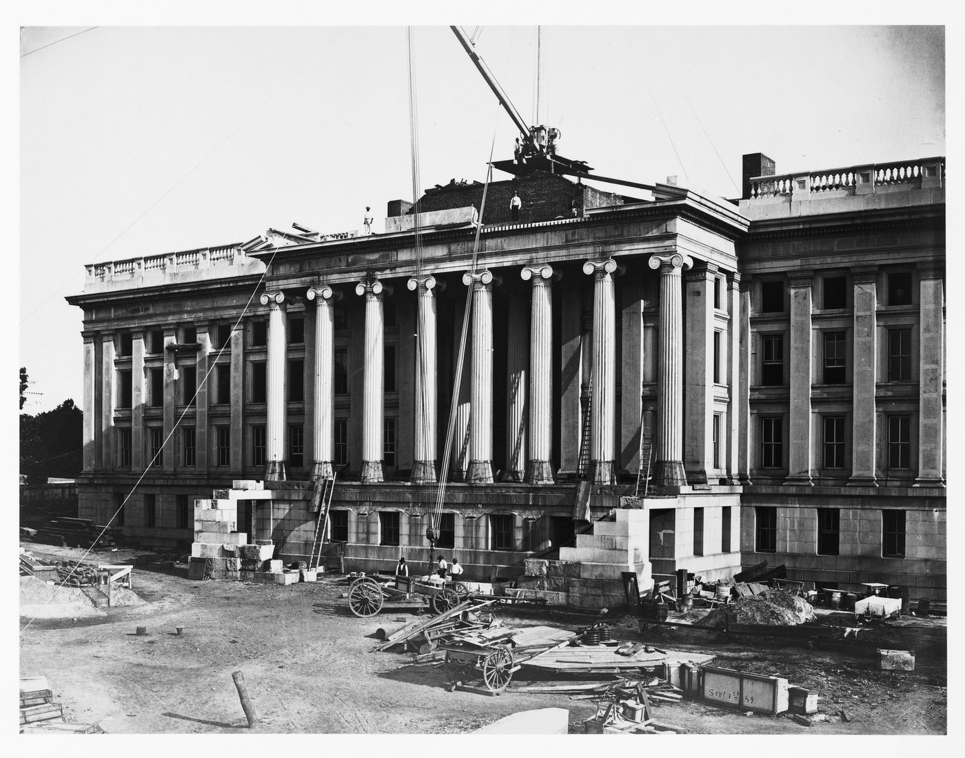 Treasury Building under contruction: Workmen operating crane, hoisting wagon, Washington, District of Columbia