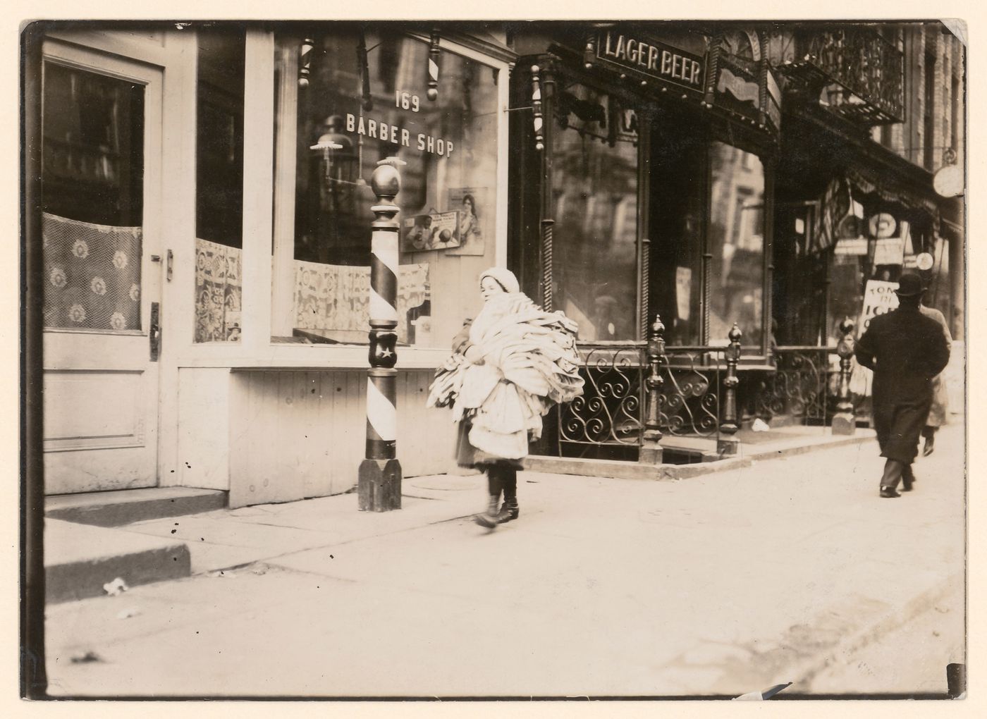 View of a girl walking down Thompson Street carrying a load of kimonos, New York City, New York, United States