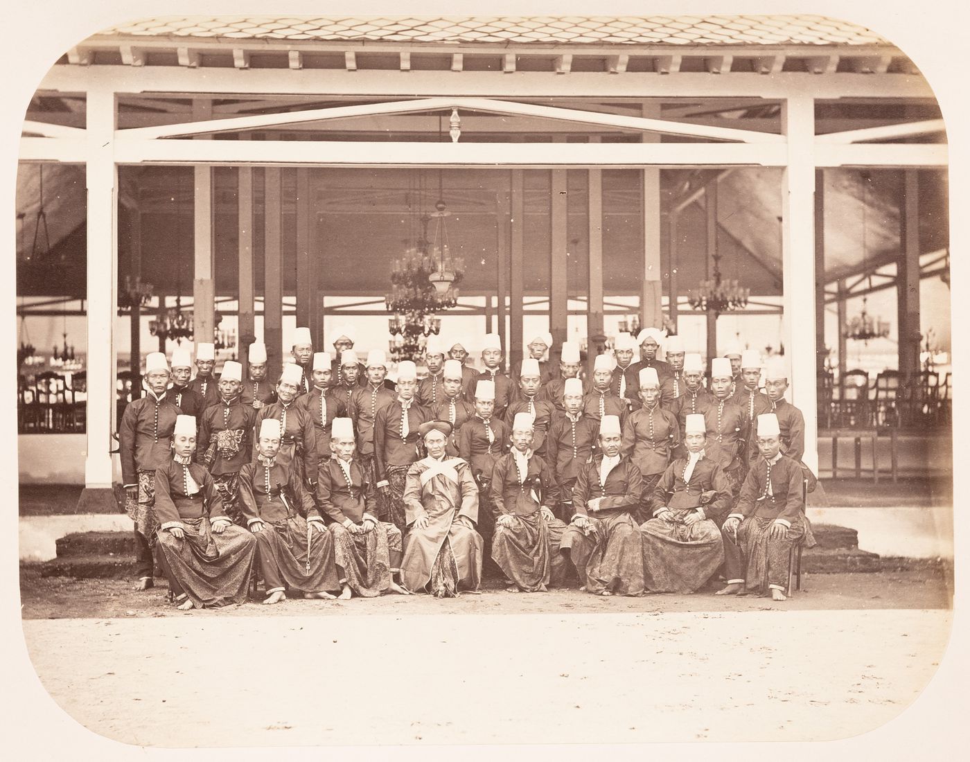 Group portrait of the retinue of Prince Mangkunegara IV showing tthe pendopo of the Puro Mangkunegaran, Solo (now Surakarta), Dutch East Indies (now Indonesia)