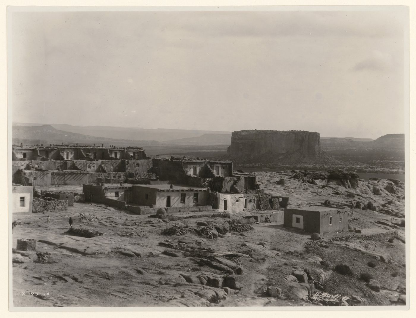 View of terraced houses with Katzimo (also known as the Enchanted Mesa) in the distant right, Acoma, New Mexico, United States