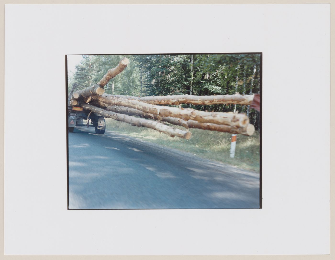 View of timber projecting from the back of a logging truck showing a road and trees, Dlugie, near Strzelce Kraje'nskie, Poland (from the series "In between cities")