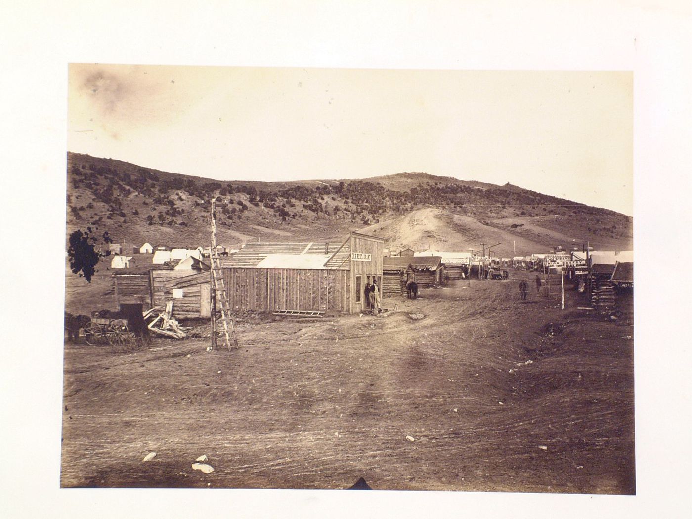 One street town with log buildings including one marked "RR Restaurant", Bear River City, Utah