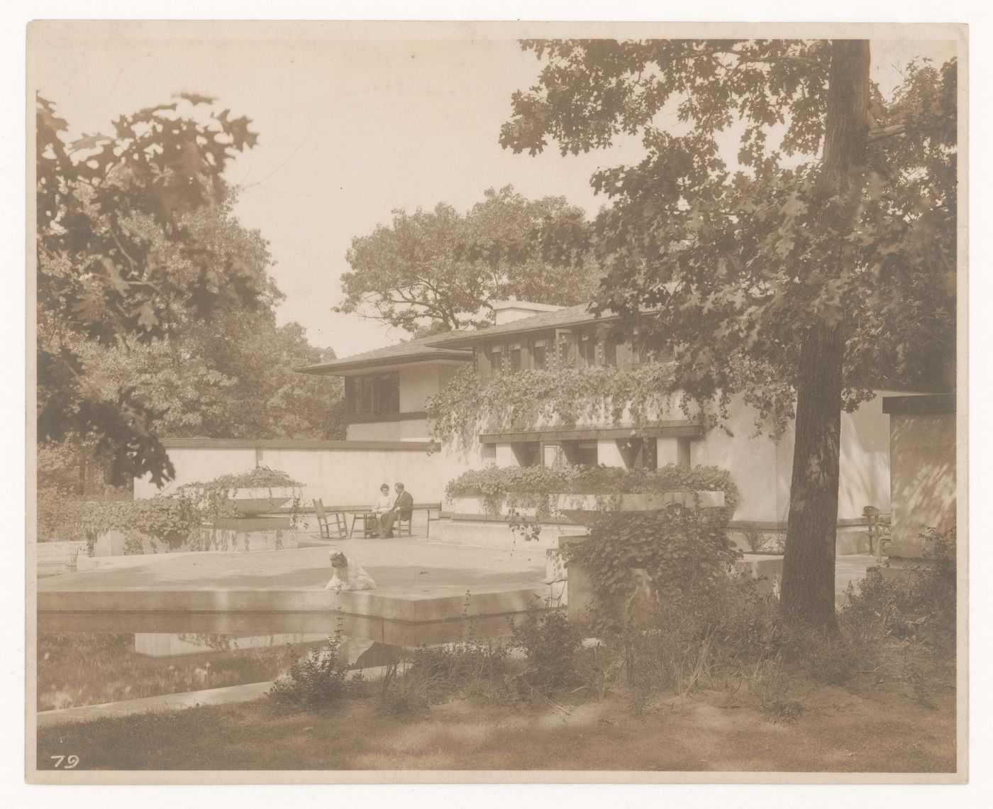 Exterior view of Coonley House showing Queene Ferry Coonley [?], Avery Coonley [?] and their daughter sitting by the pool, Riverside, Illinois