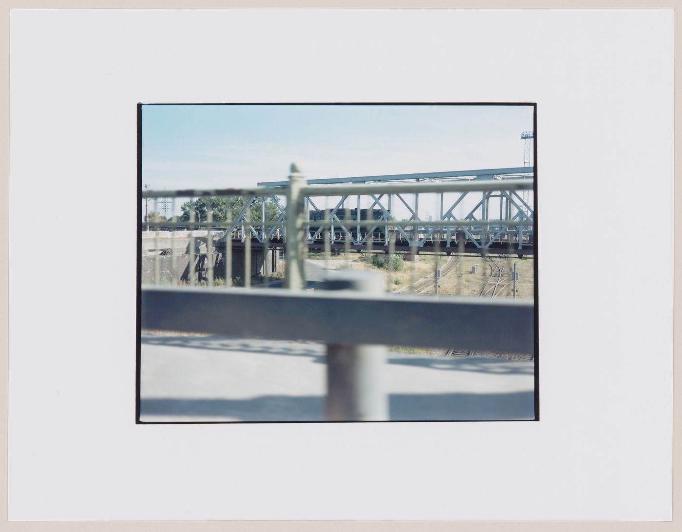 View of a railroad bridge, a train and tracks showing railings in the foreground, Kaliningradskaia oblast', Russia