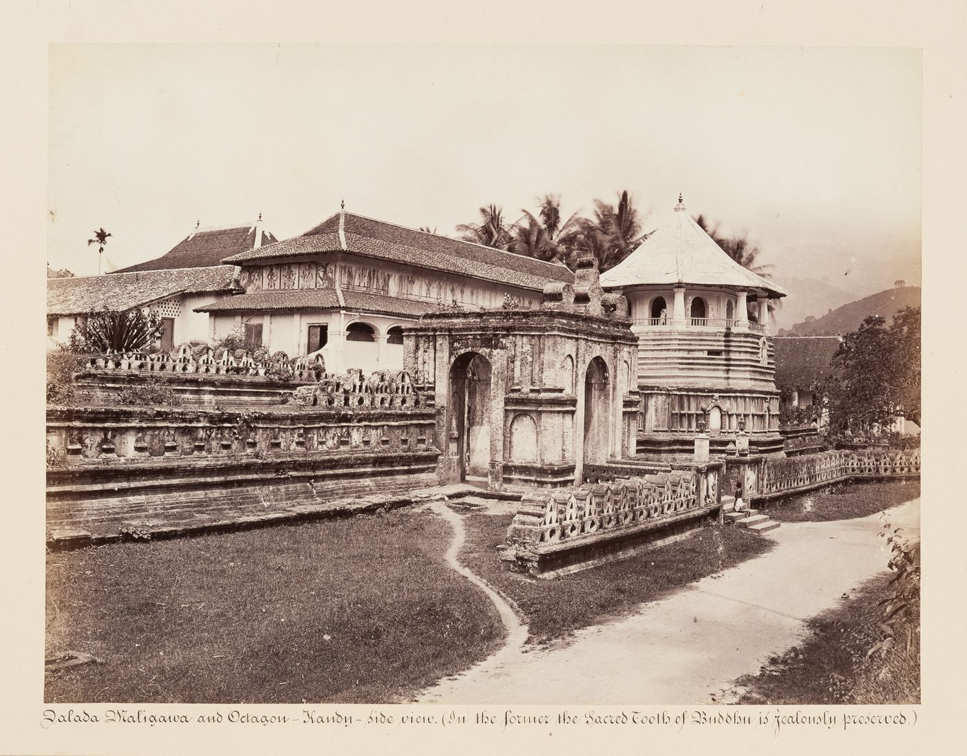 View of the entrance gateway and walls of the Temple of the Tooth (also known as the Sri Dalada Maligawa) with temple buildings in the background, Kandy, Ceylon (now Sri Lanka)