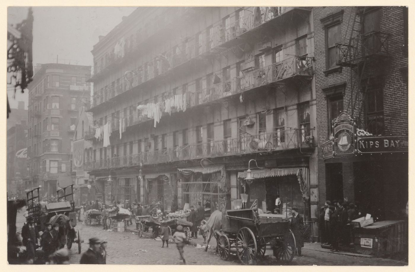 View of tenement houses where some residents work at home finishing garments, 260-268 Elizabeth Street, New York City, New York, United States