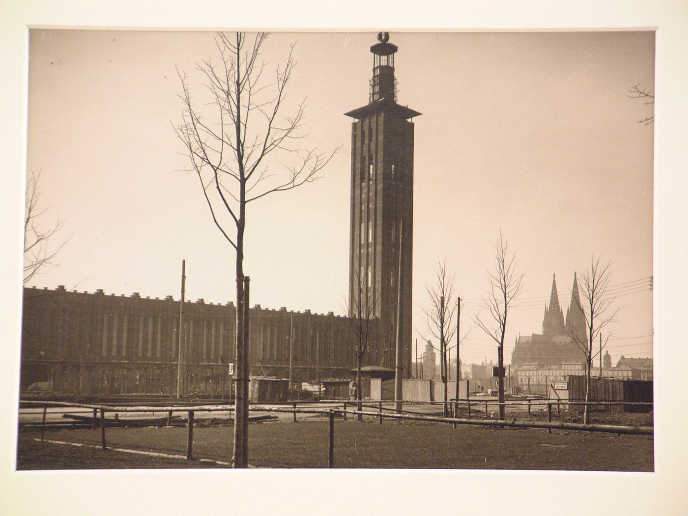 View of large modern building with tall tower, cathedral in distance, Cologne, Germany