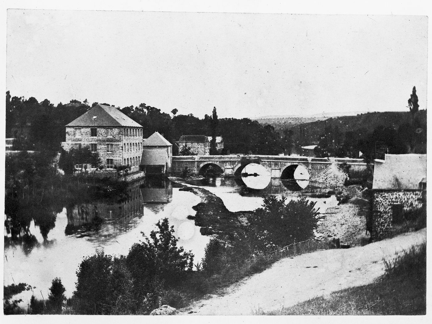View of a stone bridge with three arches crossing the river Orne, Pont-d'Ouilly, France