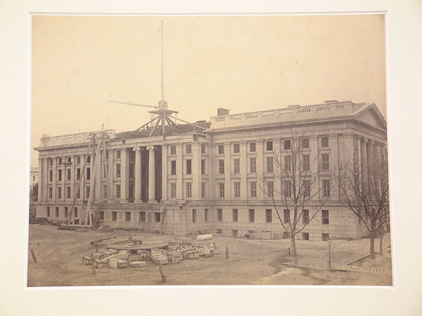 Treasury Building under contruction: Workmen and crane on scaffolding in center roof section, Washington, District of Columbia