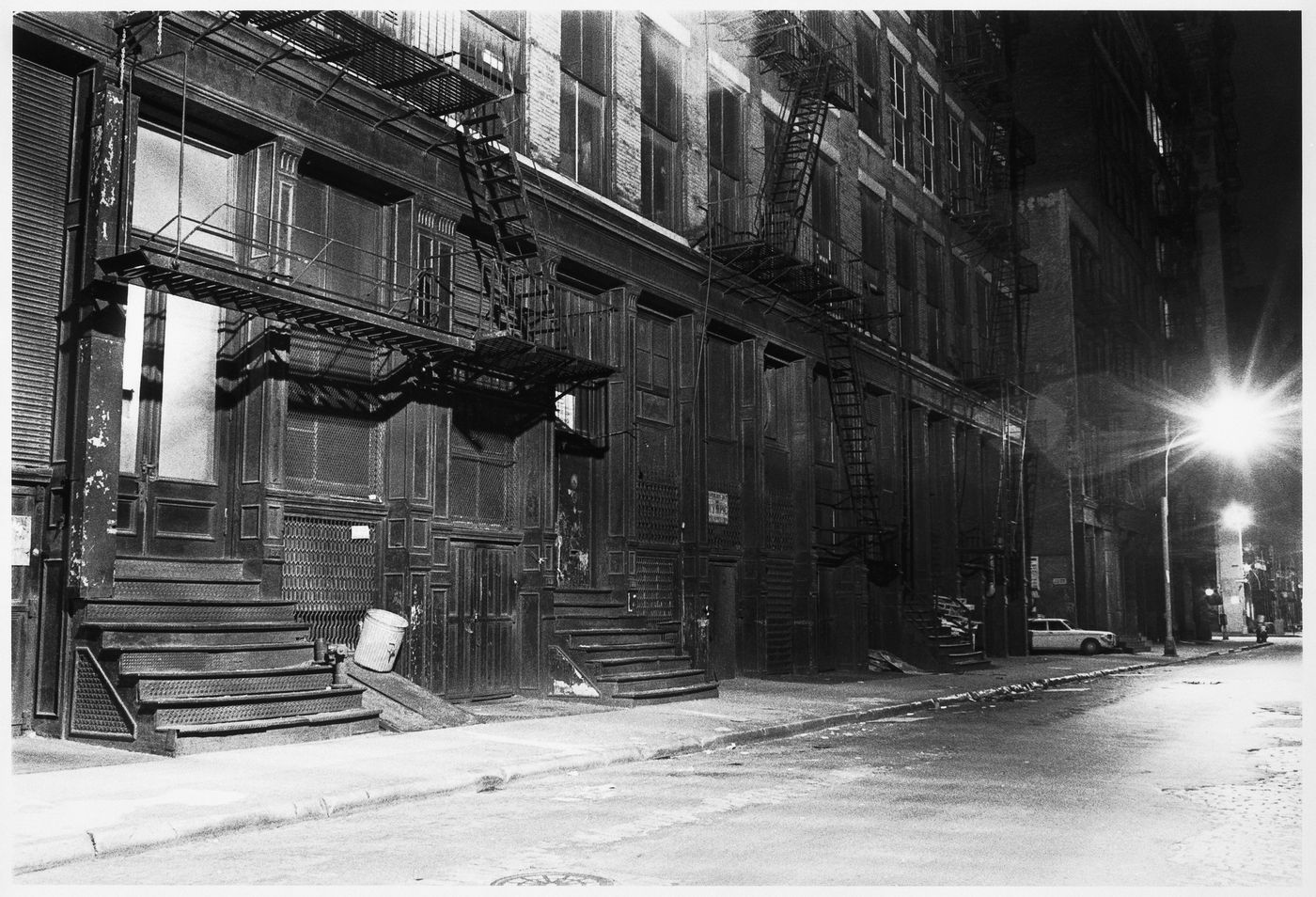 View of apartment houses at night in Soho showing fire escapes, New York City, New York