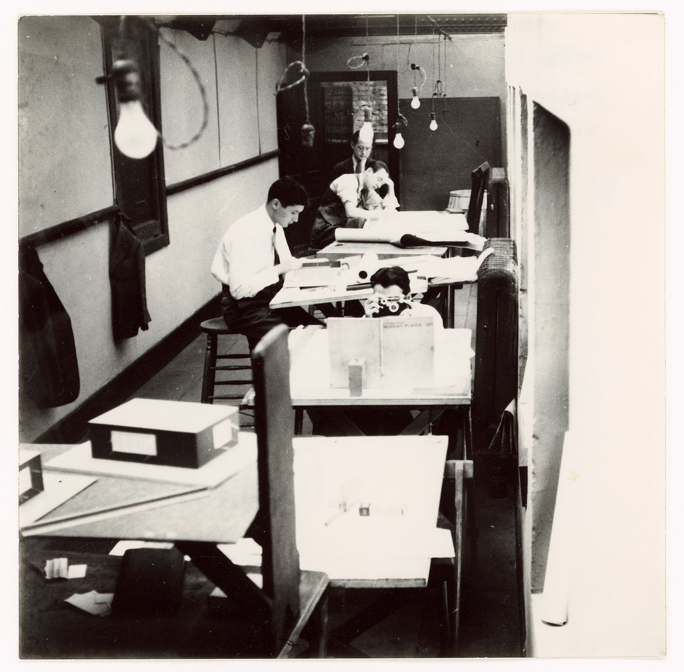 Graduate students (front to back): George Danforth (with camera), Paul Campagna, G. Scott, and C. Worley (?) in the Armour Institute's drafting rooms at the Art Institute of Chicago