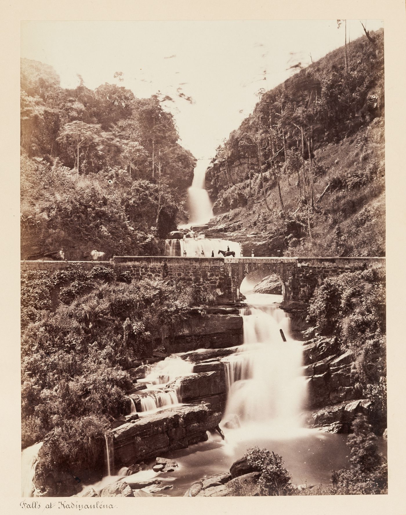 View of a bridge and the Kadialena Falls (also known as Kadiyenaléna Falls), Kotinalu [?], Ceylon (now Sri Lanka)