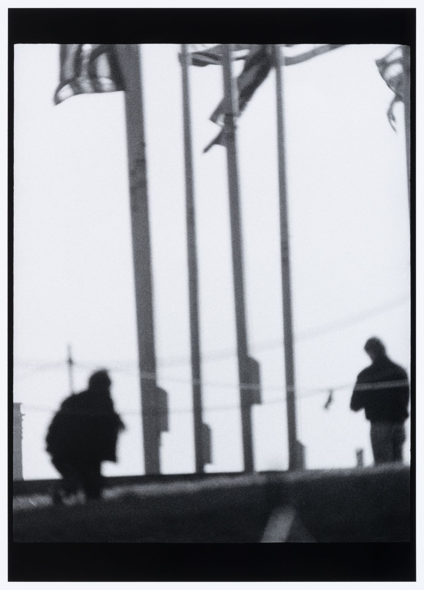 View of two men in shadow and flagpoles, probably near the Washington Monument, Washington D.C., United States, from the series "Empire"