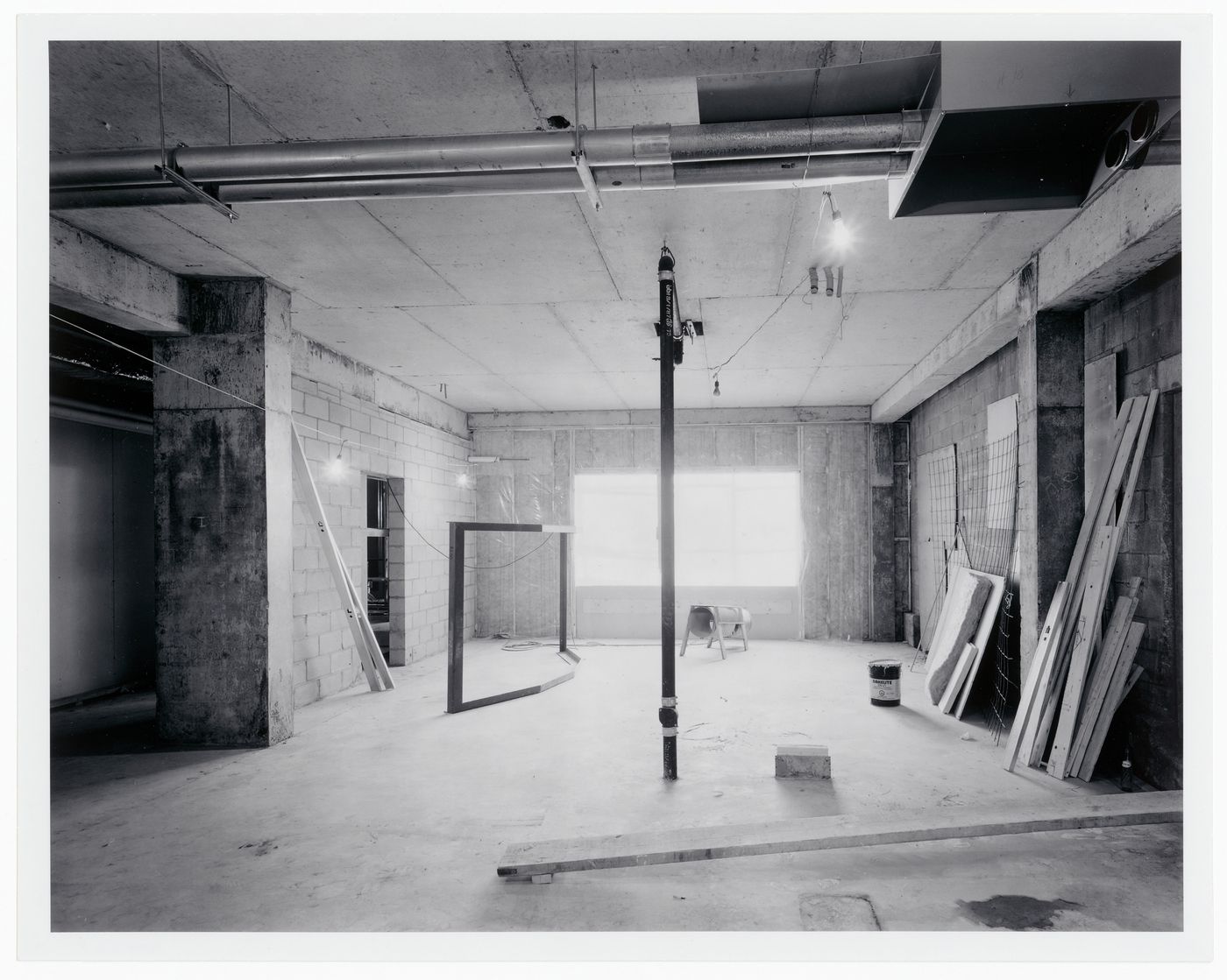 Interior view of the curatorial level [?] showing a window opening, a window frame prior to installation, and pipes, Canadian Centre for Architecture under construction, Montréal, Québec