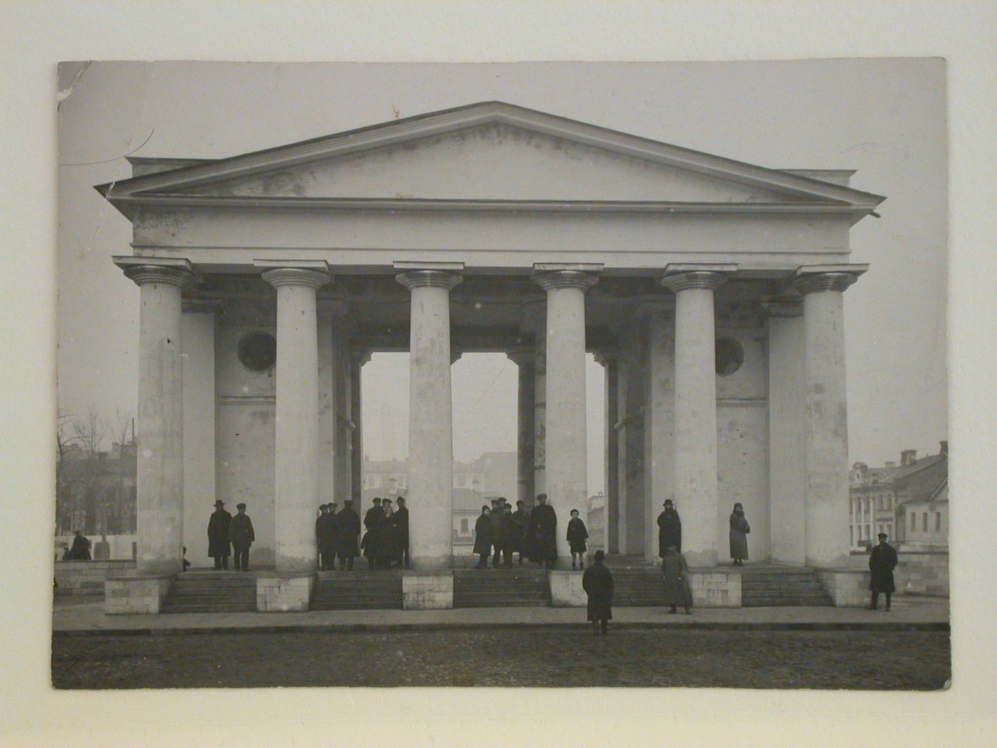 Exterior view of the colonnade of the Tverskaia Police Department Building on Sovetskaia Square (formerly Tverskaia Square and Skobelevskaia Square), showing people on the steps, Moscow