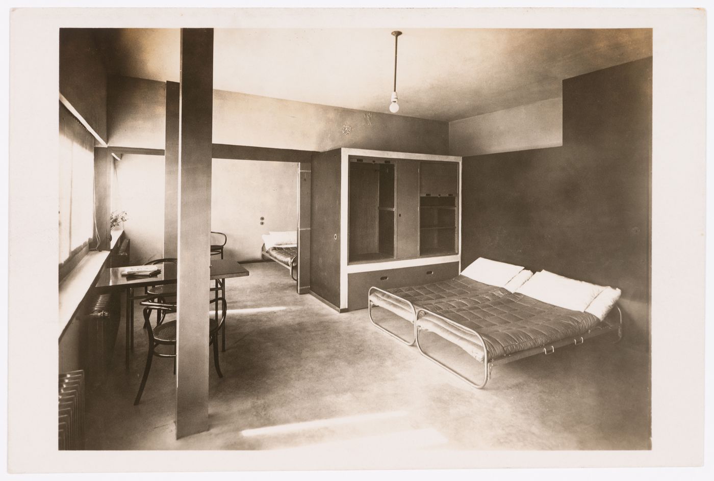 Interior view of the main living space of House 15 showing a storage cabinet and folding beds installed for use, Weissenhofsiedlung, Stuttgart, Germany