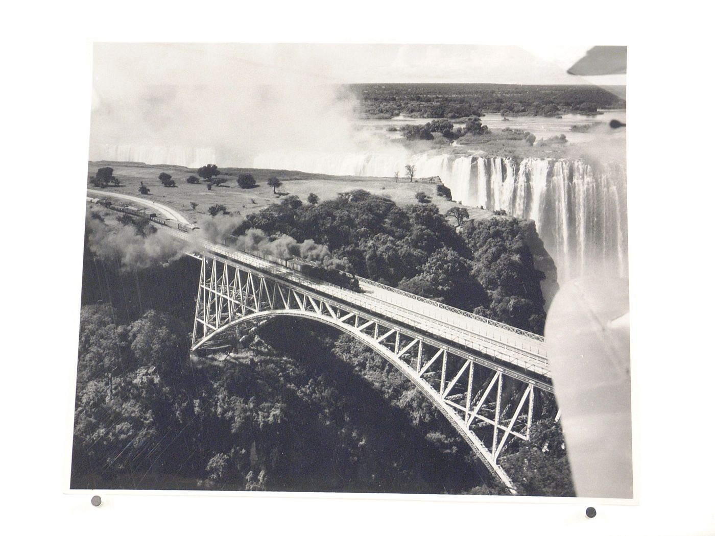 View of train on railway and waterfall, Victoria Falls Bridge, taken from above Zambezi River, crossing the border between Victoria Falls, Zimbabwe and Livingstone, Zambia