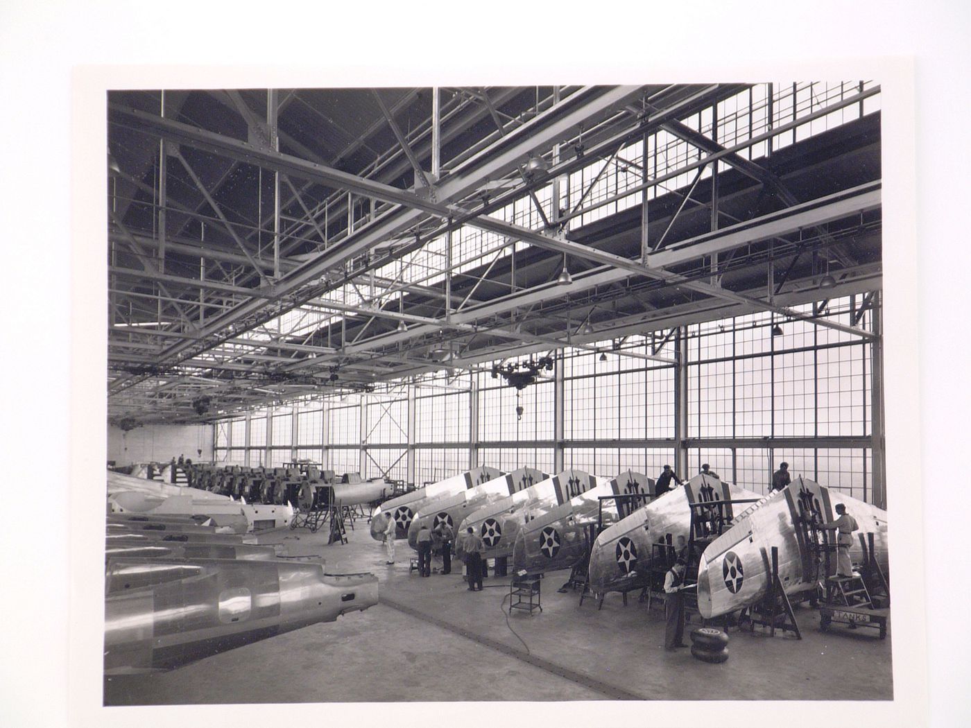 Interior view of the Assembly Building showing workers assembling airplanes, Curtiss-Wright Corporation Airplane division Assembly Plant, Buffalo, New York