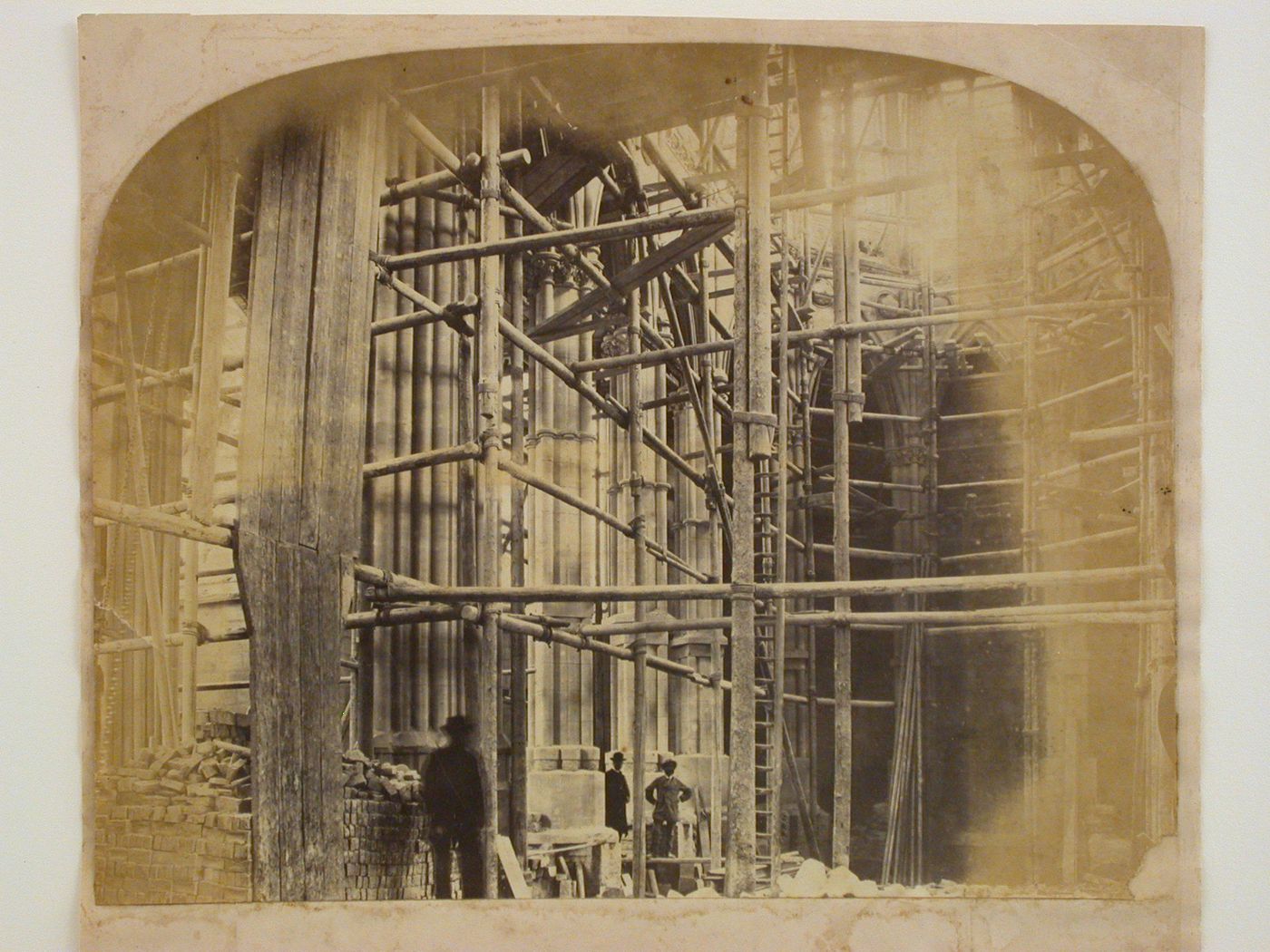 Interior view of the Church of St. Philip Neri (now the Cathedral of Our Lady and St. Philip Howard) under construction, prior to the construction of the floor and showing scaffolds, construction material and men, Arundel, West Sussex, England