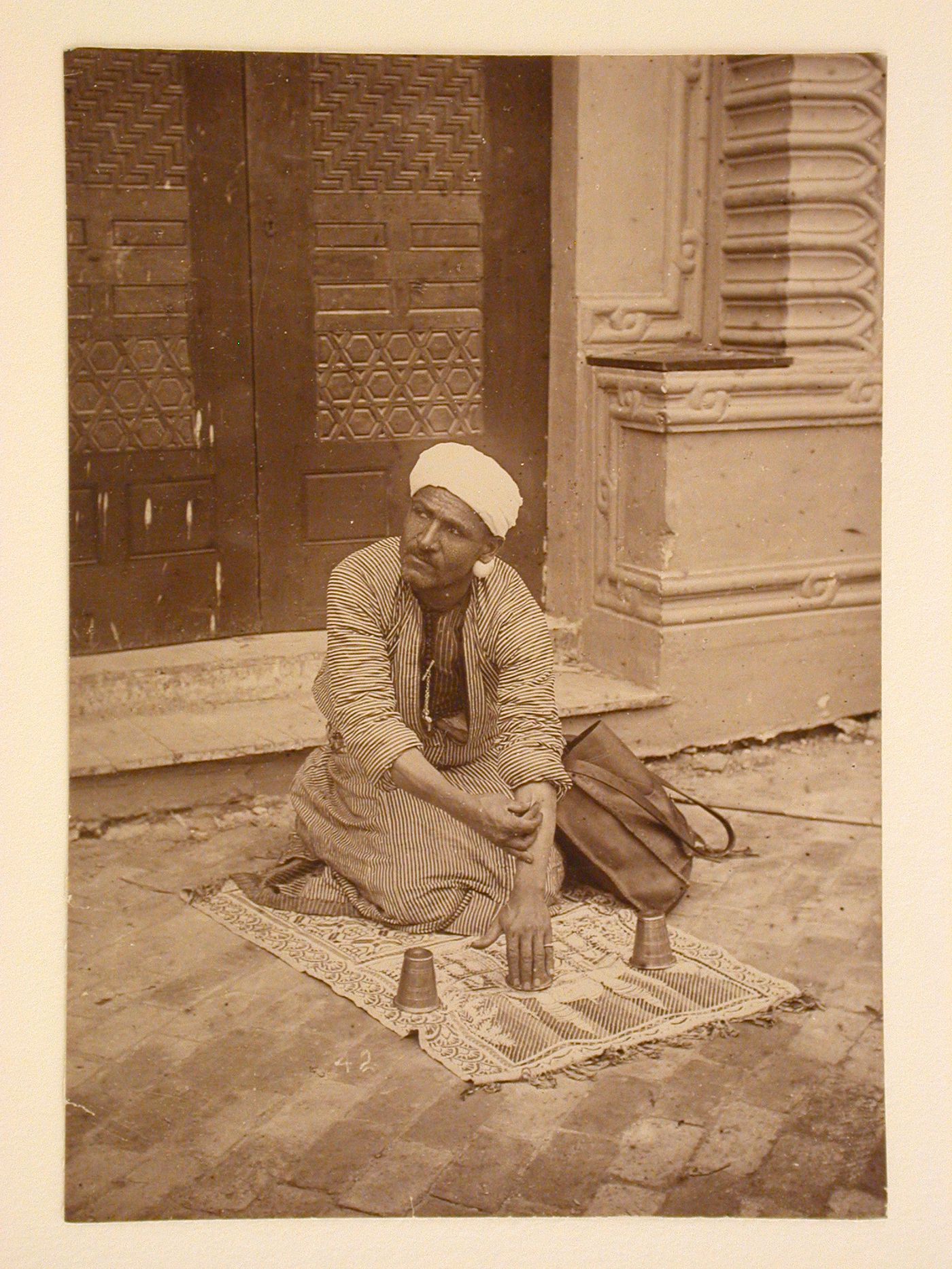 Portrait of a man on a throw rug on Cairo [?] Street, 1893 Chicago World's Columbian Exhibition, Chicago, Illinois