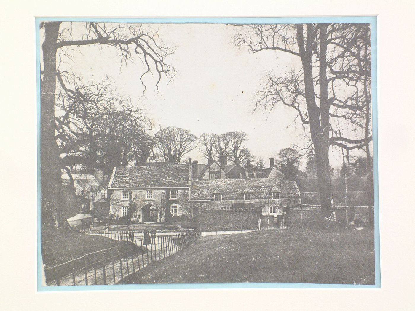 View of houses in a village, three figures in the road, England