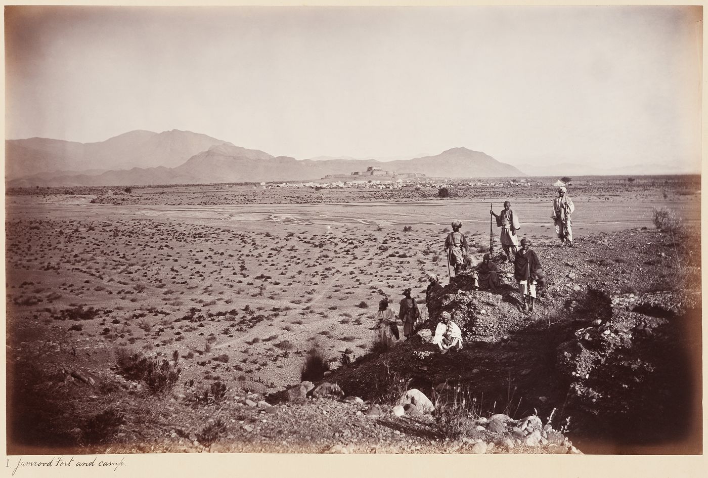 Distant view of Jamrud Fort, a British military camp and mountains with men in the foreground, Jamrud, India (now in Pakistan)