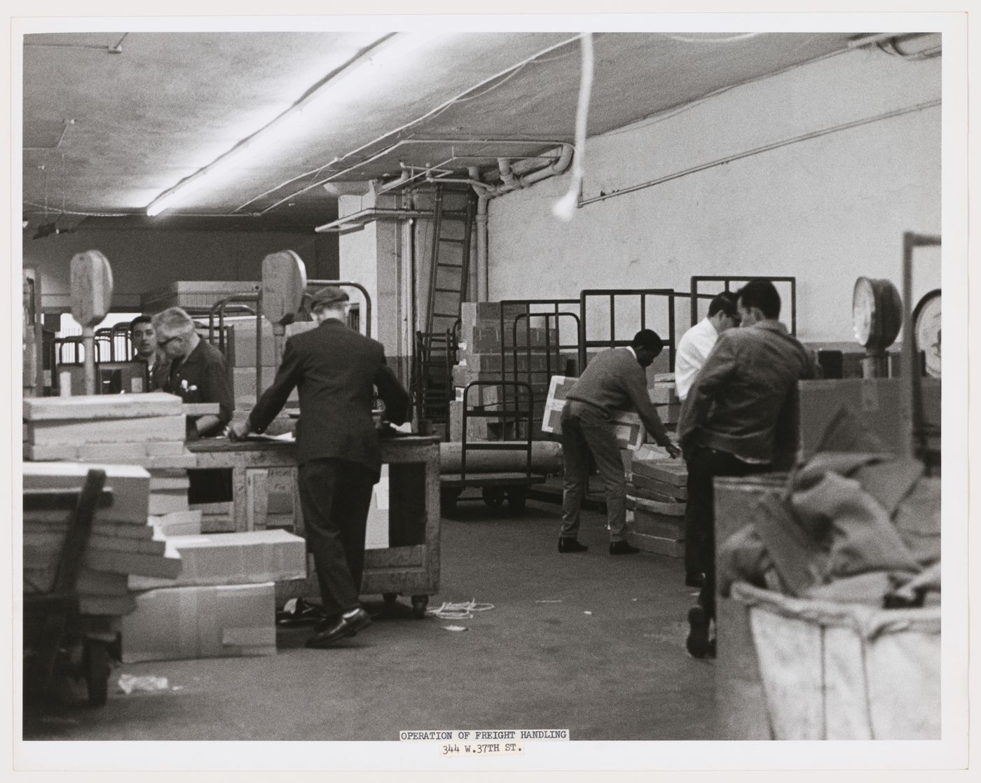 Interior view of a building showing workers handling freight, West 37th Street, Manhattan, New York City, New York