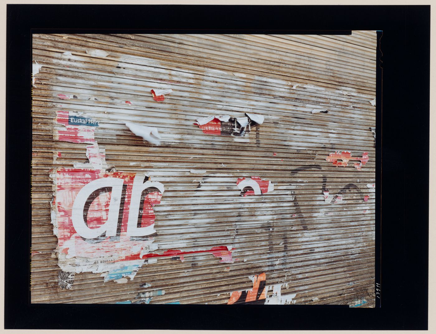 View of a wall bearing graffiti and torn posters, Puente la Reina, Spain (from the series "In between cities")