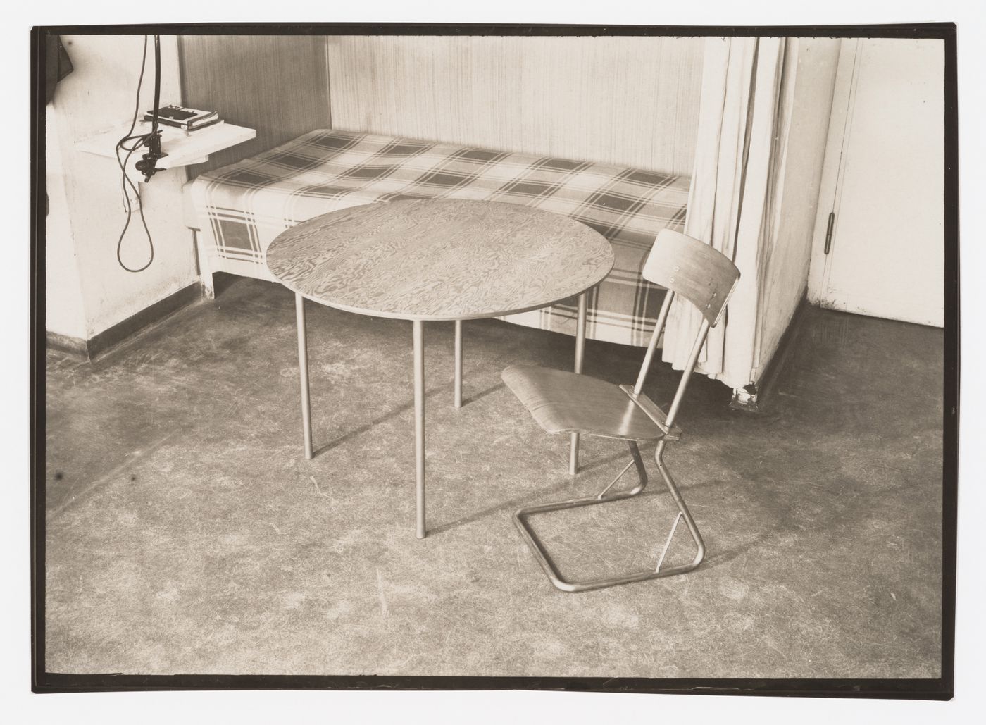 Interior view of a studio apartment in the Bauhaus building showing a bed, round table and side chair designed by Marcel Breuer, Dessau, Germany