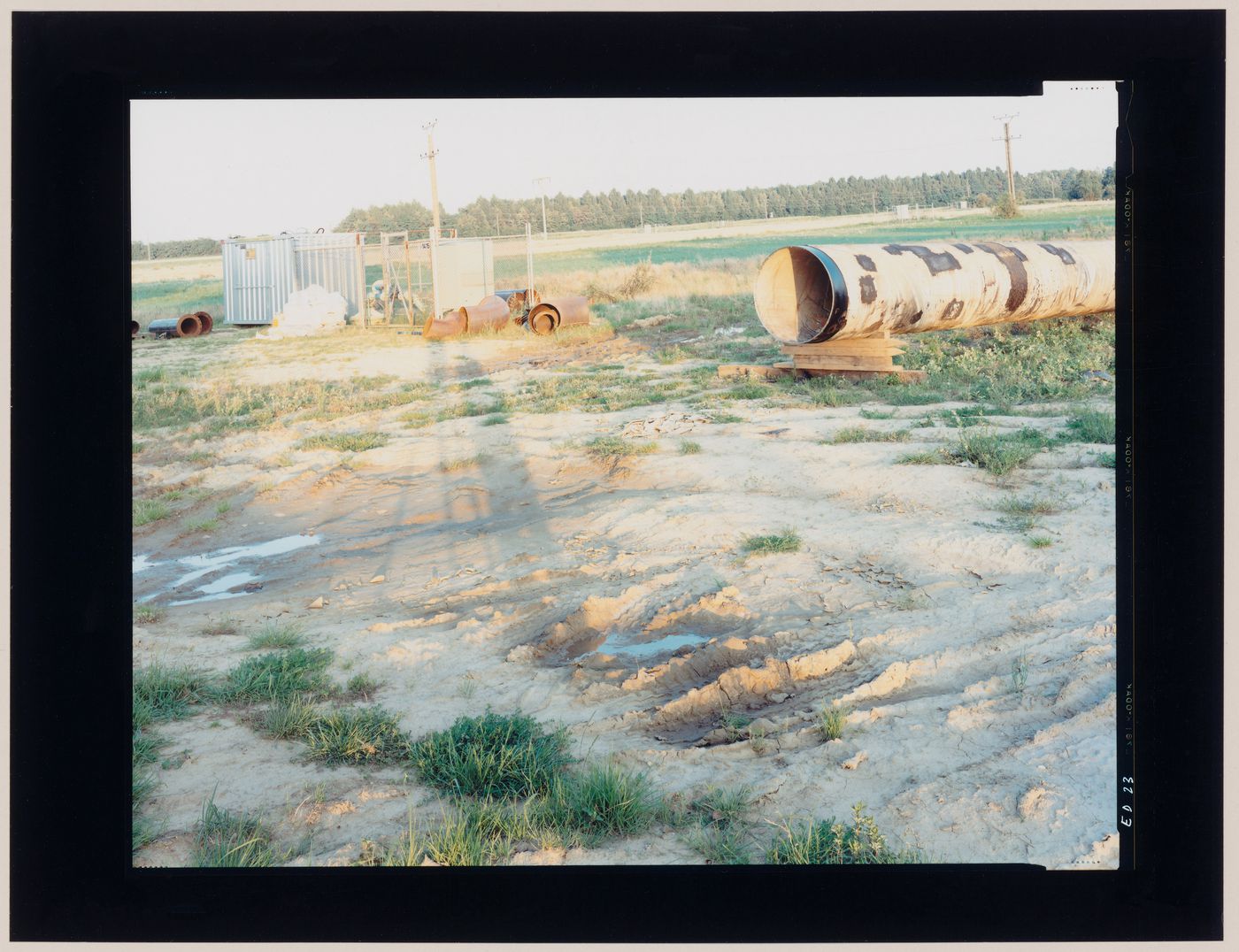 View of a main and other large pipes, a vacant lot and arable land, Jülich, Germany (from the series "In between cities")